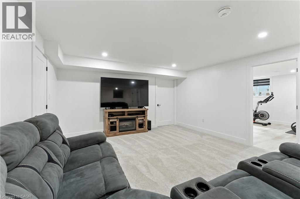 Living room with light carpet, recessed lighting, and a fireplace - 9 Macneil Court, Port Burwell, ON - Indoor