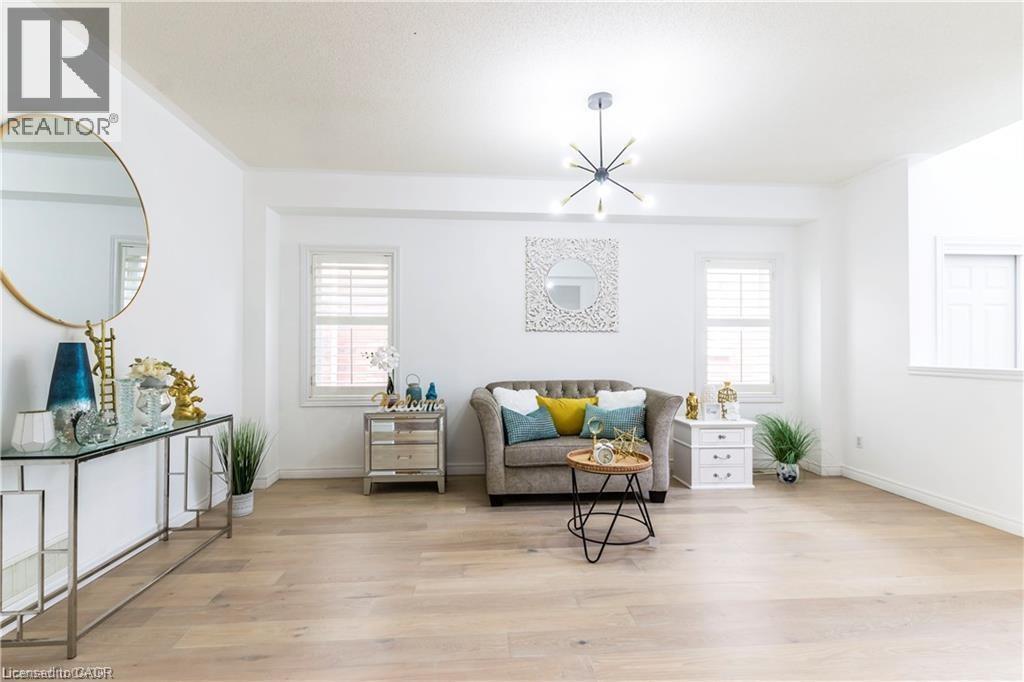 Sitting room featuring suspended lighting, light wood-style flooring, and plenty of natural light - 252 Thorner Drive Unit# Upper, Hamilton, ON - Indoor Photo Showing Living Room