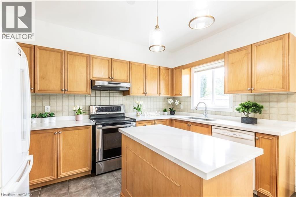 Kitchen with stainless steel electric range oven, a center island, freestanding refrigerator, decorative light fixtures, and backsplash - 252 Thorner Drive Unit# Upper, Hamilton, ON - Indoor Photo Showing Kitchen
