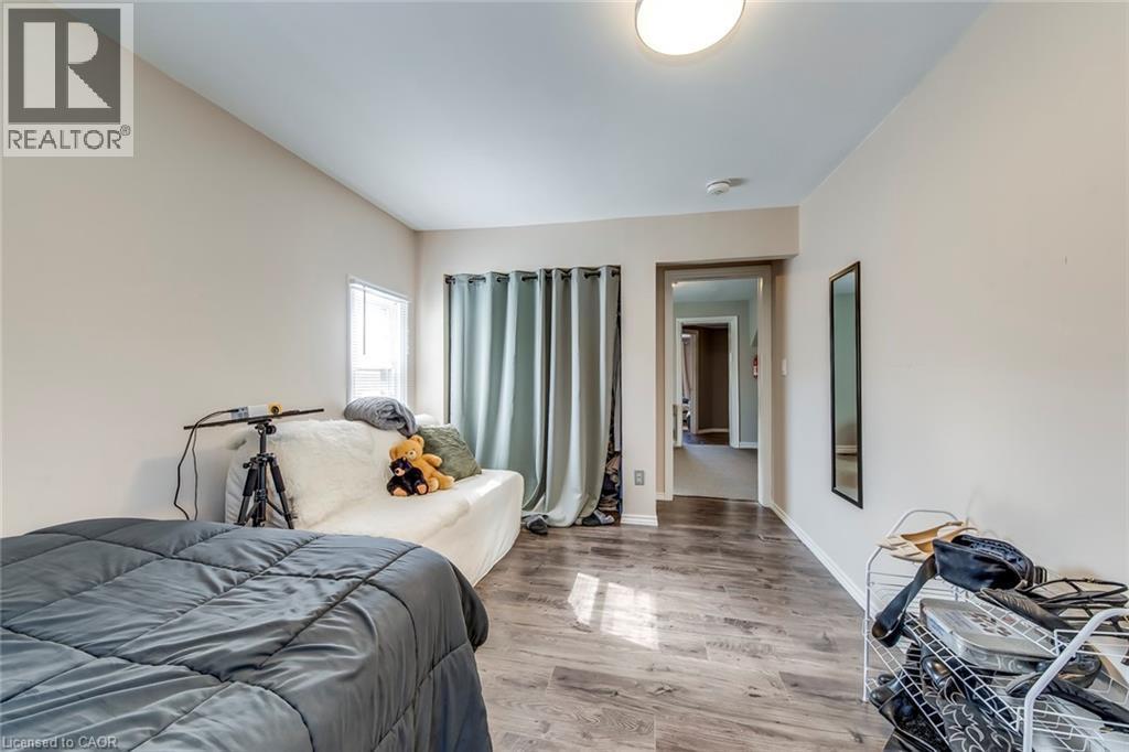 Bedroom featuring wood finished floors and baseboards - 142 Ewen Road, Hamilton, ON - Indoor Photo Showing Bedroom
