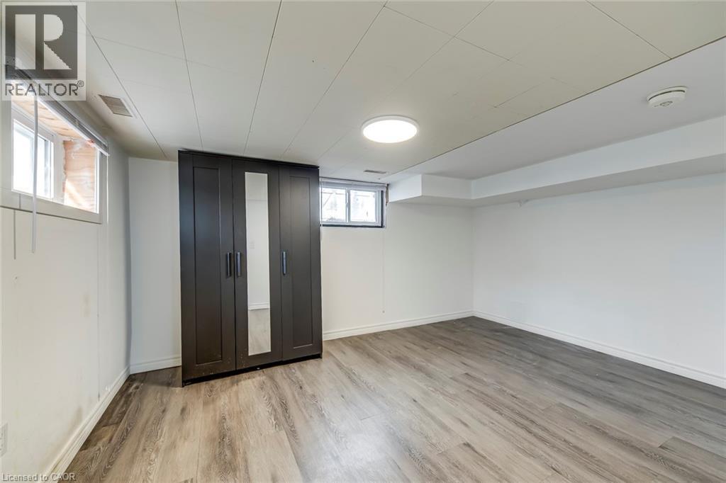 Below grade area with light wood finished floors and baseboards - 142 Ewen Road, Hamilton, ON - Indoor Photo Showing Other Room