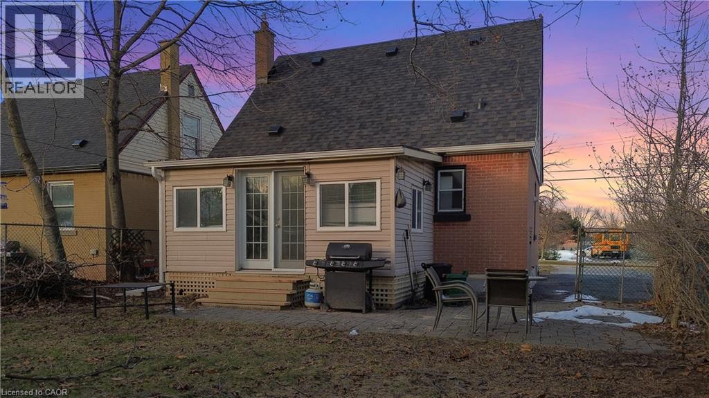 Back of house featuring a patio area, brick siding, a shingled roof, and a chimney - 776 Britannia Avenue, Hamilton, ON - Outdoor