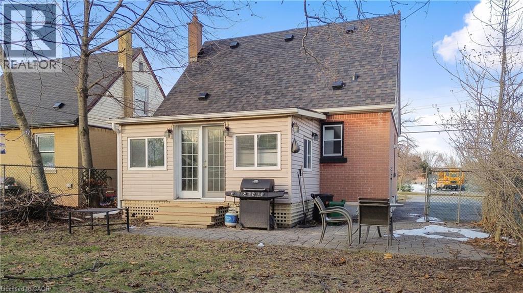 Back of property featuring a patio area, roof with shingles, brick siding, and a chimney - 776 Britannia Avenue, Hamilton, ON - Outdoor