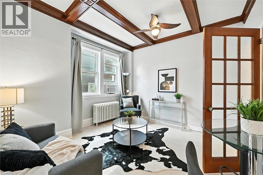 Living area with radiator, ceiling fan, beam ceiling, and coffered ceiling - 1047 Main Street E, Hamilton, ON - Indoor