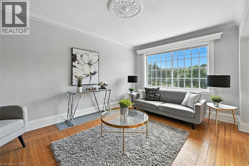 Living area with a textured ceiling, hardwood / wood-style floors, and crown molding - 1047 Main Street E, Hamilton, ON - Indoor Photo Showing Living Room