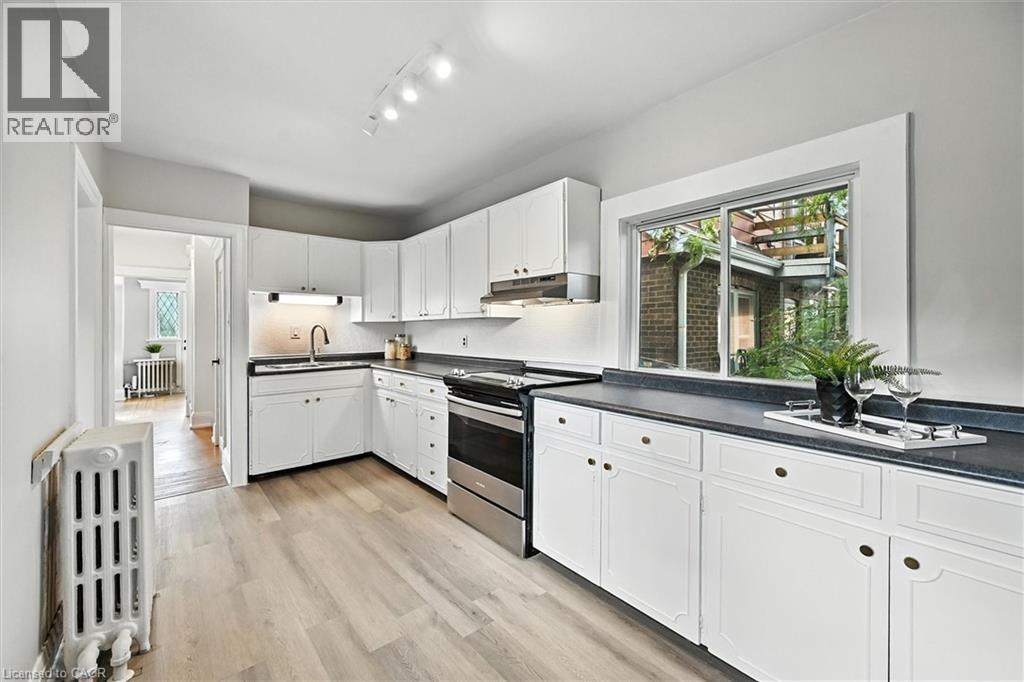 Kitchen with electric range, white cabinets, and dark countertops - 1047 Main Street E, Hamilton, ON - Indoor Photo Showing Kitchen