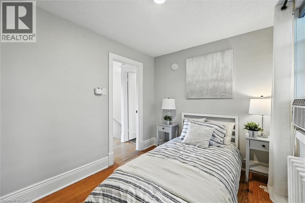 Bedroom with dark wood-style flooring and a textured ceiling - 1047 Main Street E, Hamilton, ON - Indoor Photo Showing Bedroom