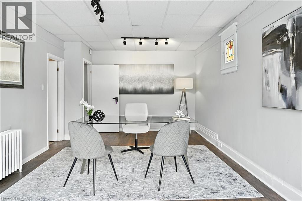 Home office featuring rail lighting, radiator heating unit, and dark wood-type flooring - 1047 Main Street E, Hamilton, ON - Indoor