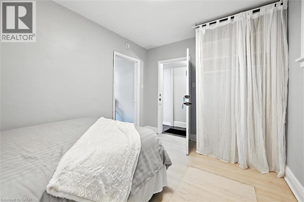 Bedroom with light wood-style flooring and baseboards - 1047 Main Street E, Hamilton, ON - Indoor Photo Showing Bedroom