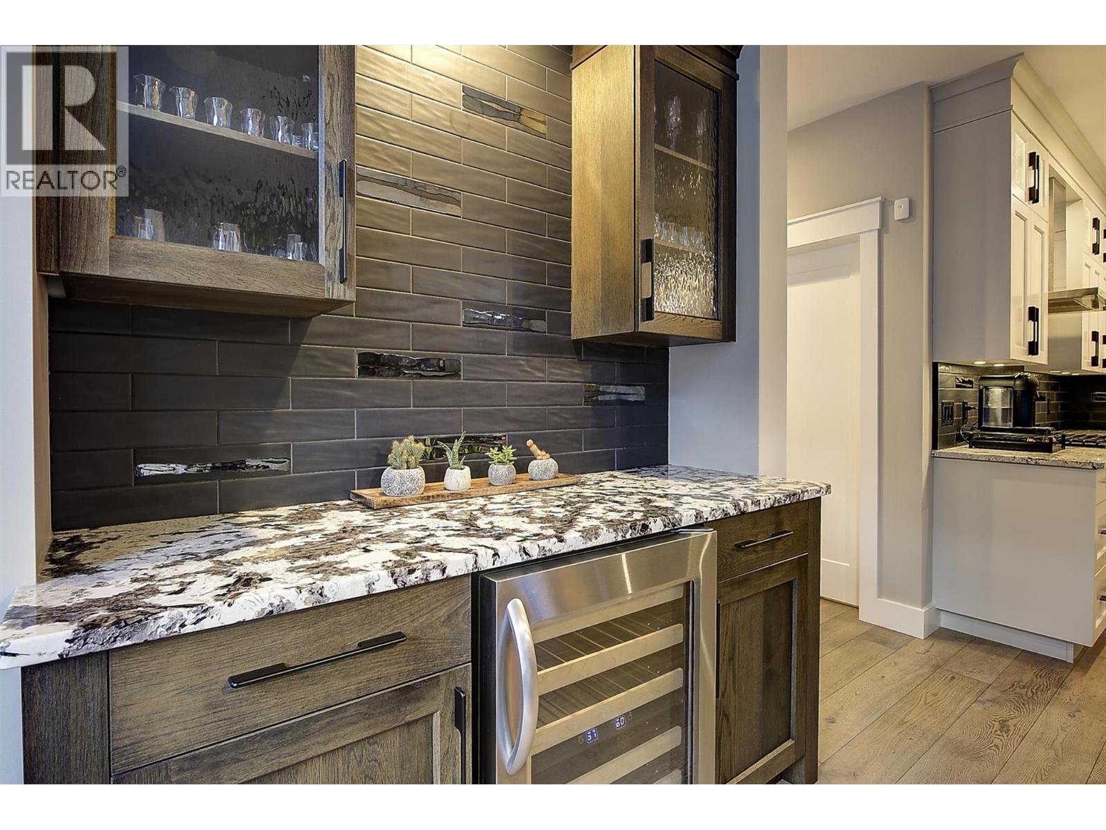 Wine fridge / Wet bar off kitchen and dining area - 5499 Mountainside Drive, Kelowna, BC - Indoor Photo Showing Kitchen With Upgraded Kitchen