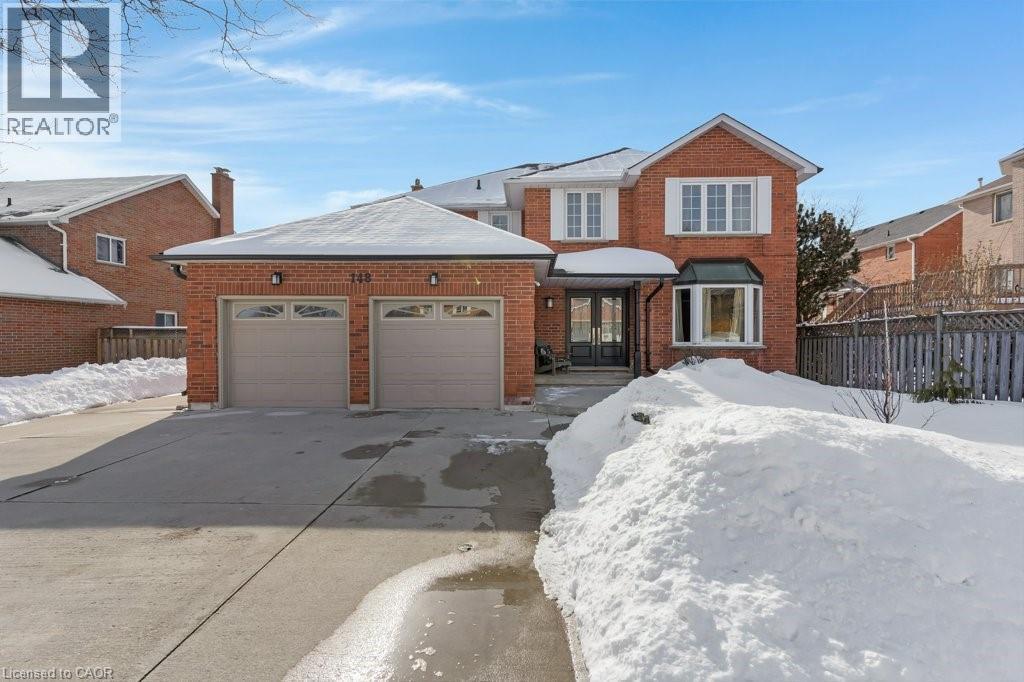 Traditional home featuring brick siding, an attached garage, and driveway - 148 Cowan Boulevard, Cambridge, ON - Outdoor