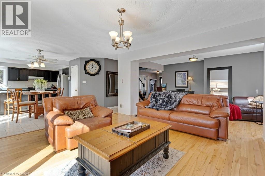 Living area with light wood finished floors, hanging lights, and a ceiling fan - 148 Cowan Boulevard, Cambridge, ON - Indoor Photo Showing Living Room