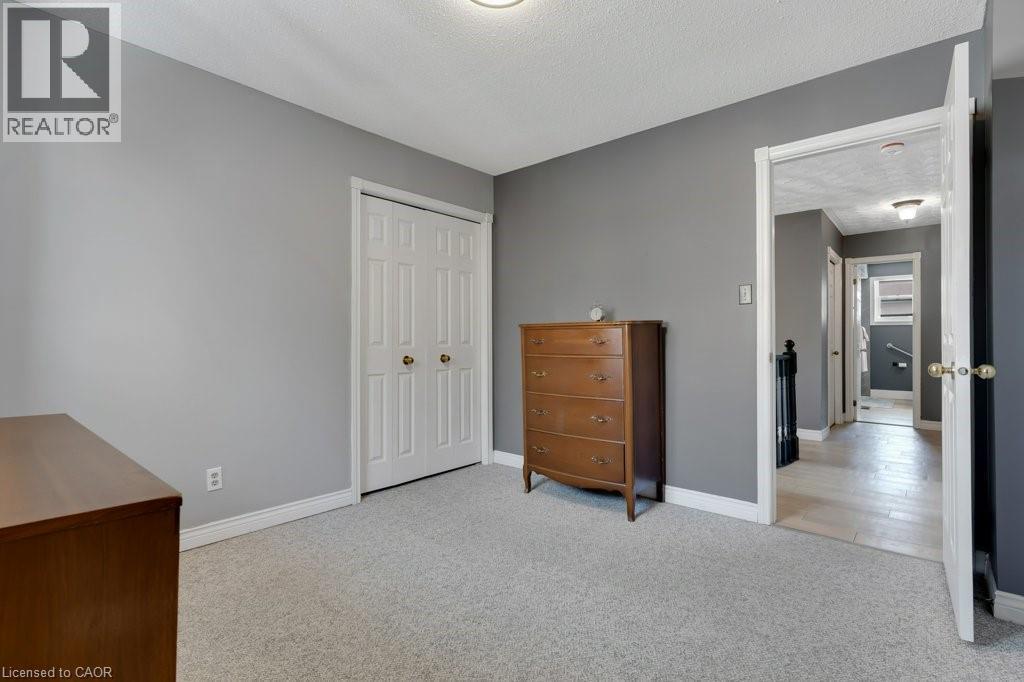 Unfurnished bedroom with light colored carpet, a textured ceiling, and a closet - 148 Cowan Boulevard, Cambridge, ON - Indoor