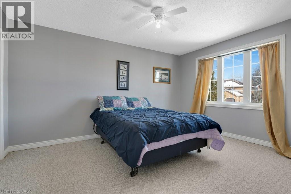 Lower level Bedroom featuring light carpet, a textured ceiling, and ceiling fan - 148 Cowan Boulevard, Cambridge, ON - Indoor Photo Showing Bedroom