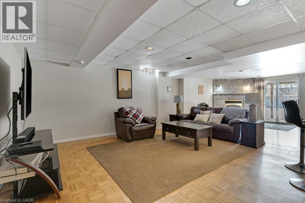 Living area with a paneled ceiling, a fireplace, and parquet floors - 148 Cowan Boulevard, Cambridge, ON - Indoor