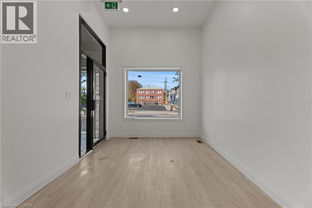 Empty room featuring light wood-type flooring and recessed lighting - 93 John Street S, Hamilton, ON