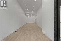 Hallway with recessed lighting and light wood-type flooring -