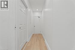 Hall with light wood-type flooring and recessed lighting -
