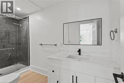 Full bathroom with vanity, a marble finish shower, light wood-type flooring, and recessed lighting -