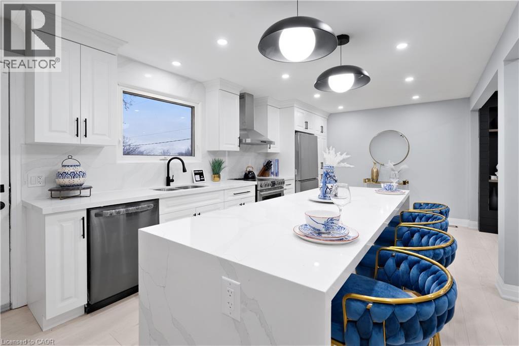Kitchen with a kitchen island, white cabinetry, light stone countertops, stainless steel appliances, and recessed lighting - 19 Broad Street, Brantford, ON - Indoor Photo Showing Kitchen With Upgraded Kitchen