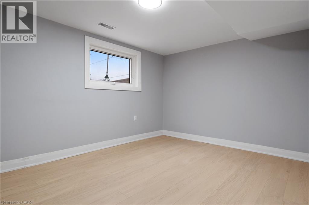 Spare room featuring baseboards and light wood-style flooring - 19 Broad Street, Brantford, ON - Indoor Photo Showing Other Room