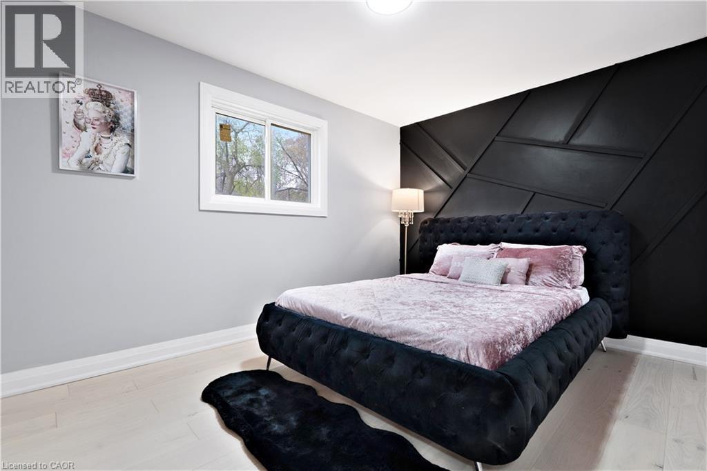 Bedroom with a decorative wall, light wood-type flooring, and an accent wall - 19 Broad Street, Brantford, ON - Indoor Photo Showing Bedroom