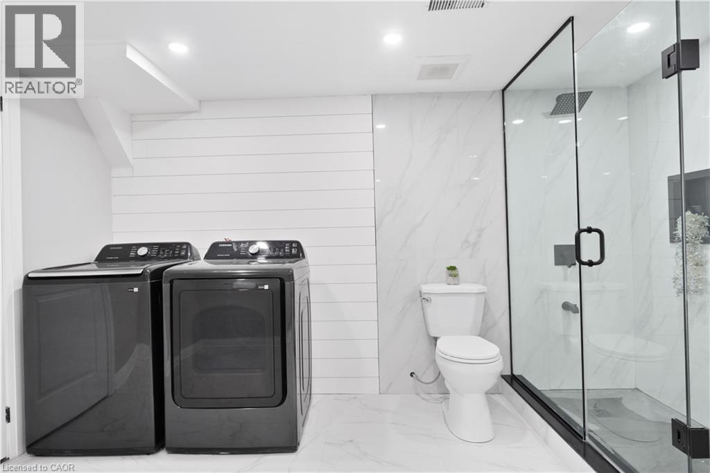 Bathroom with a marble finish shower, marble tiled flooring, washing machine and dryer, and recessed lighting - 19 Broad Street, Brantford, ON - Indoor Photo Showing Laundry Room