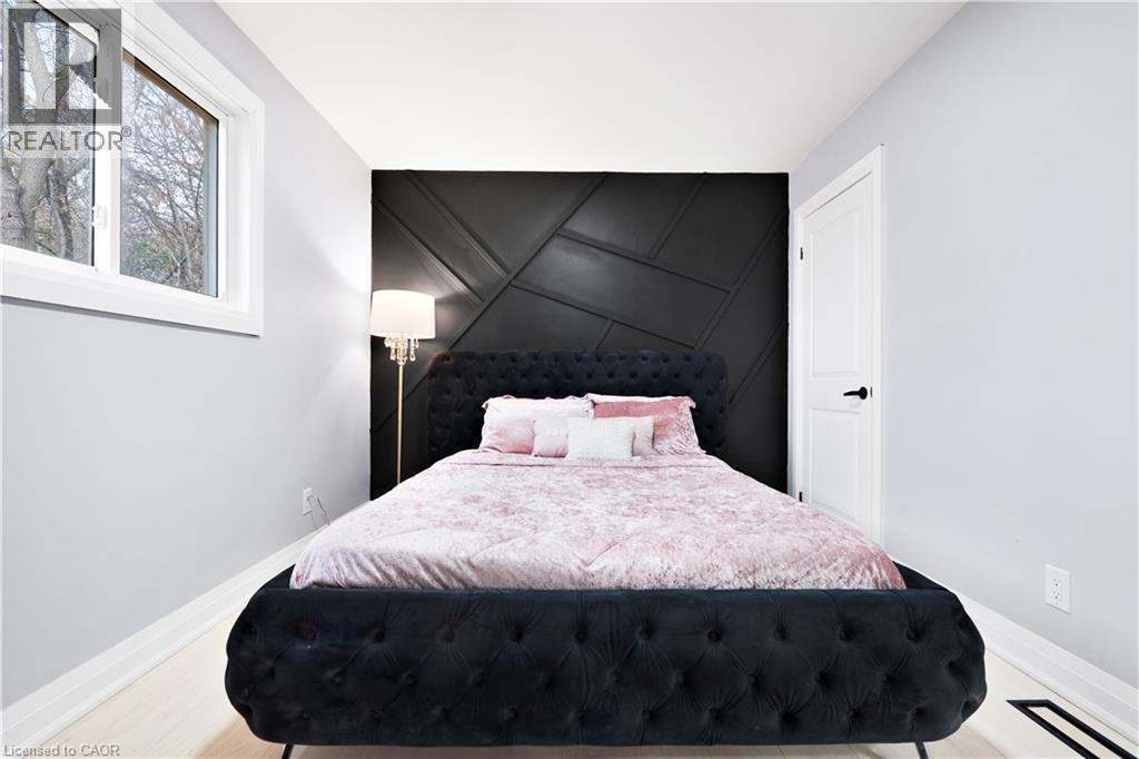 Bedroom with an accent wall, a decorative wall, and light wood-type flooring - 19 Broad Street, Brantford, ON - Indoor Photo Showing Bedroom
