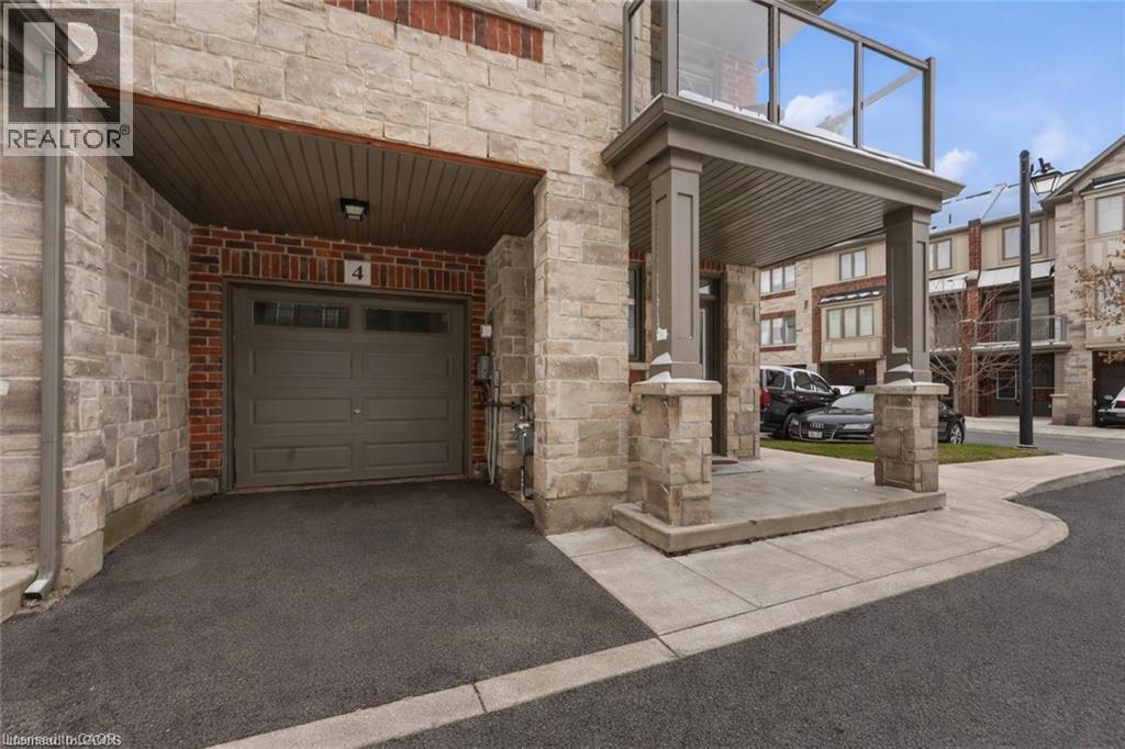 Doorway to property featuring stone siding, brick siding, a garage, and driveway - 4 Andruss Lane, Ancaster, ON - Outdoor