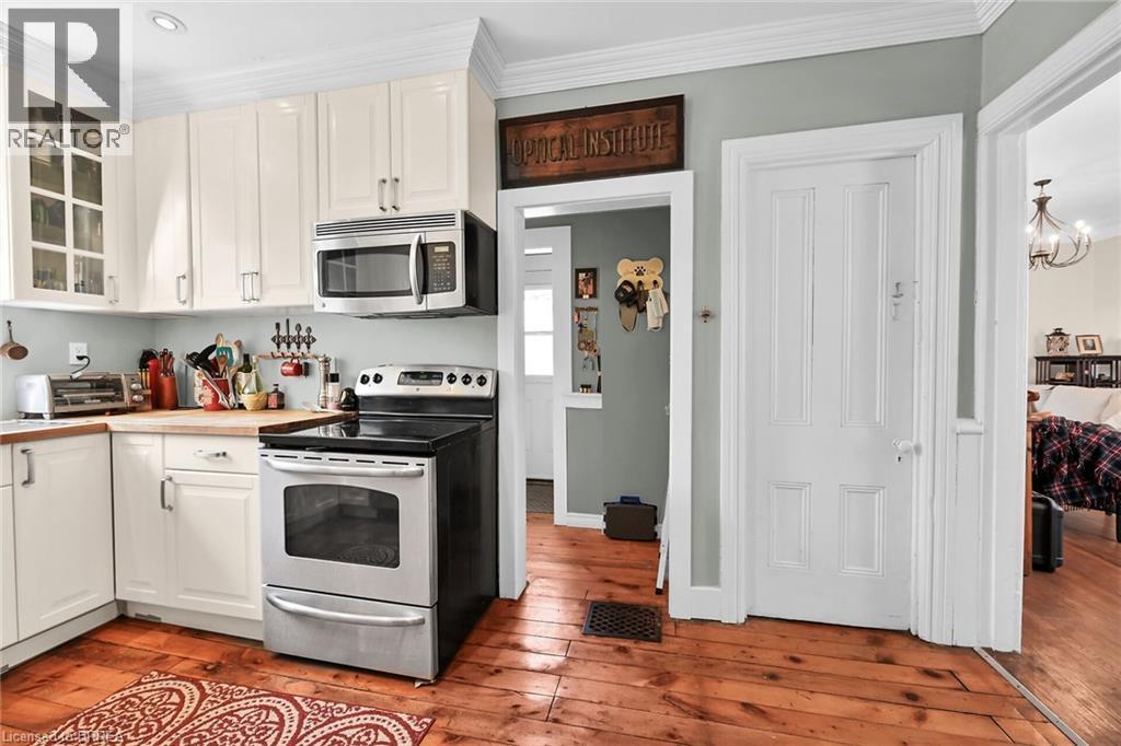 Kitchen featuring appliances with stainless steel finishes, white cabinetry, and light hardwood / wood-style flooring - 40 Locke Street S, Hamilton, ON - Indoor Photo Showing Kitchen