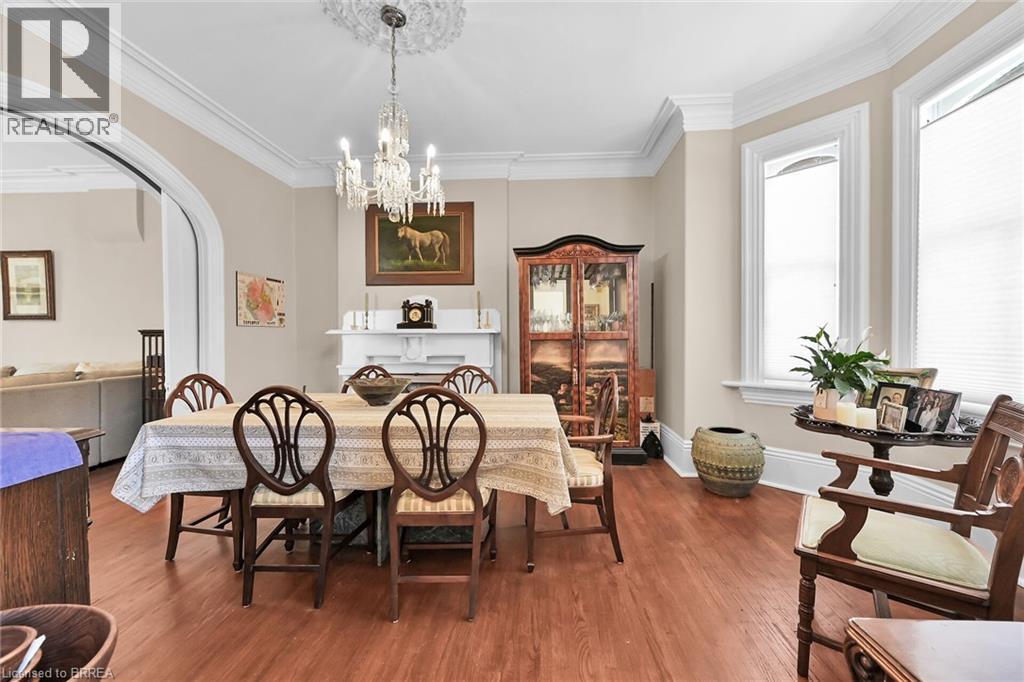 Dining space featuring a notable chandelier, ornamental molding, and hardwood / wood-style flooring - 40 Locke Street S, Hamilton, ON - Indoor Photo Showing Dining Room