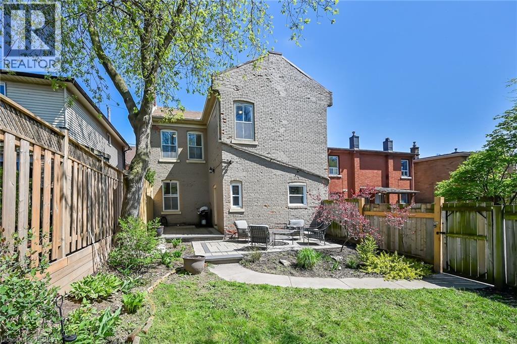 Rear view of property featuring a lawn and a patio area - 40 Locke Street S, Hamilton, ON - Outdoor