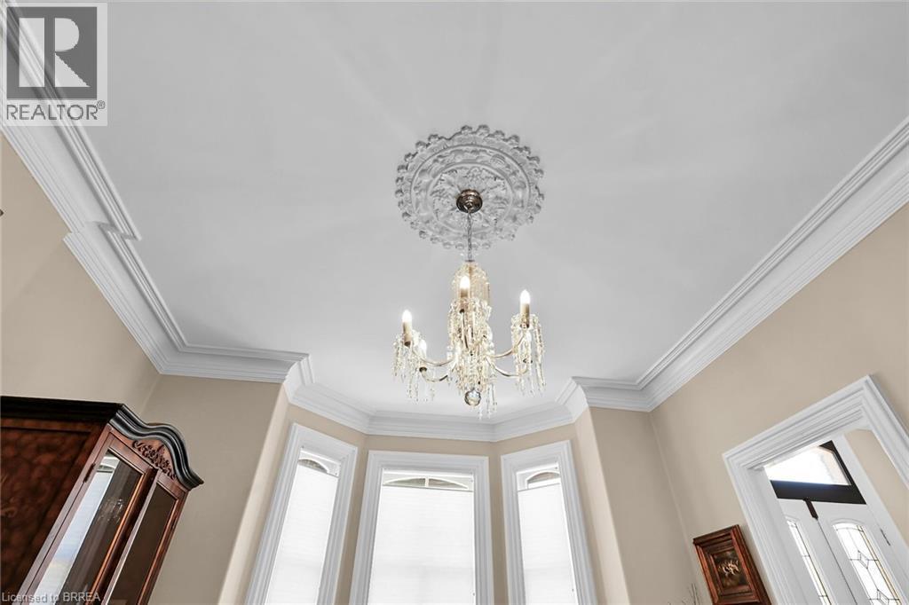 Room details featuring an inviting chandelier and ornamental molding - 40 Locke Street S, Hamilton, ON - Indoor Photo Showing Other Room