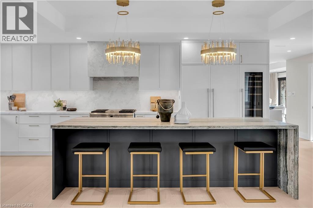 Two tone kitchen with light stone countertops, a kitchen breakfast bar, modern cabinets, a large island, and dual tone cabinetry - 841 Danforth Place, Burlington, ON - Indoor Photo Showing Kitchen With Upgraded Kitchen