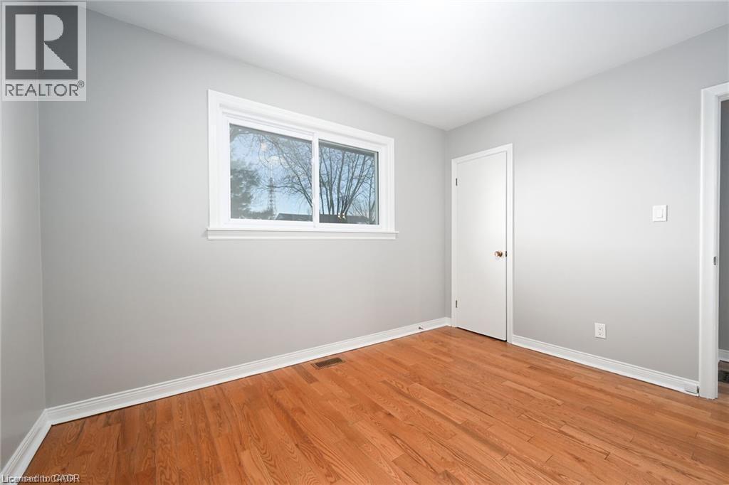 Empty room featuring baseboards and light wood-type flooring - 325 East 16Th Street, Hamilton, ON - Indoor Photo Showing Other Room