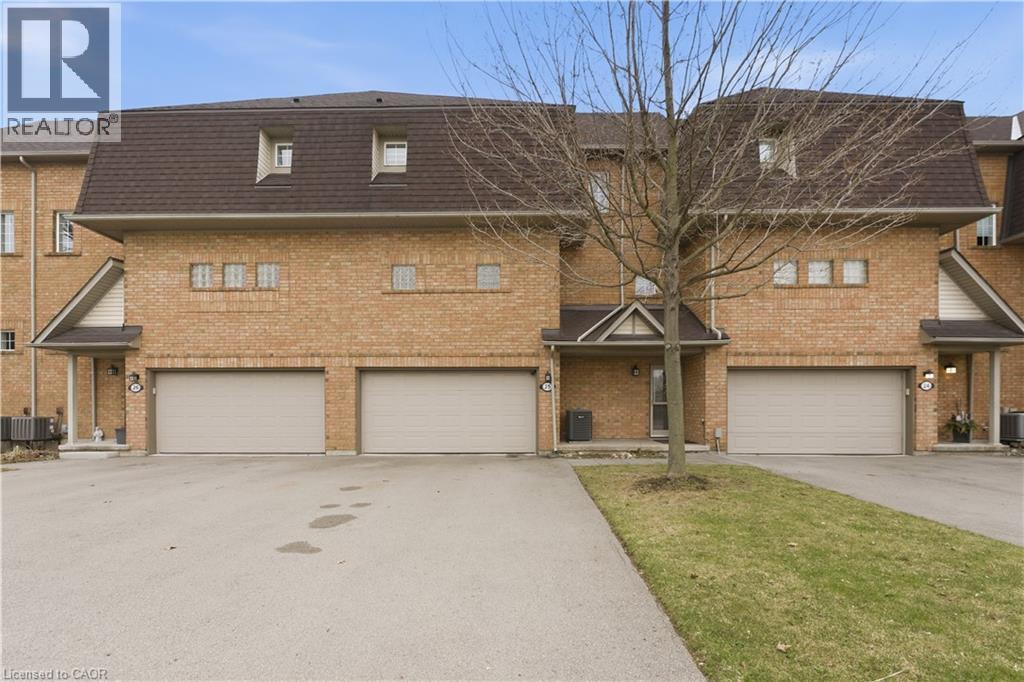 Traditional home with a garage, brick siding, and driveway - 100 Beddoe Drive Unit# 25, Hamilton, ON - Outdoor With Facade
