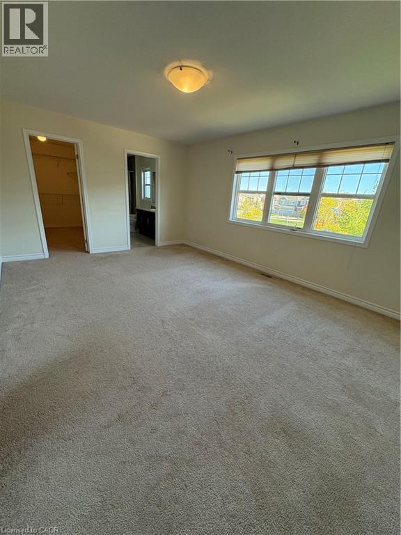 Unfurnished bedroom with a spacious closet, carpet flooring, and ensuite bath - 50 Shoreacres Drive, Kitchener, ON - Indoor Photo Showing Other Room