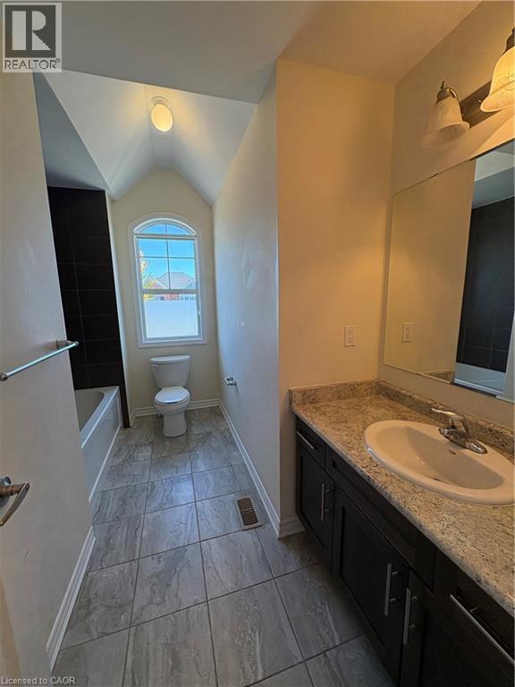 Full bathroom featuring vanity, lofted ceiling, and washtub / shower combination - 50 Shoreacres Drive, Kitchener, ON - Indoor Photo Showing Bathroom