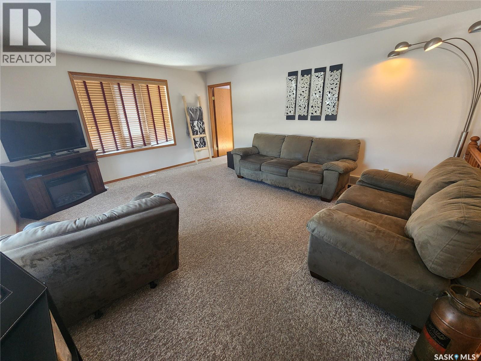 115 Carson Bay, Lampman, SK - Indoor Photo Showing Living Room With Fireplace