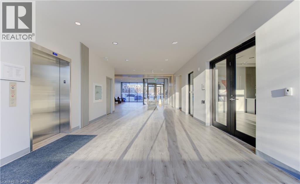 Hall featuring elevator, light wood-style floors, recessed lighting, and french doors - 103 Roger Street Unit# 310, Waterloo, ON - Indoor Photo Showing Other Room