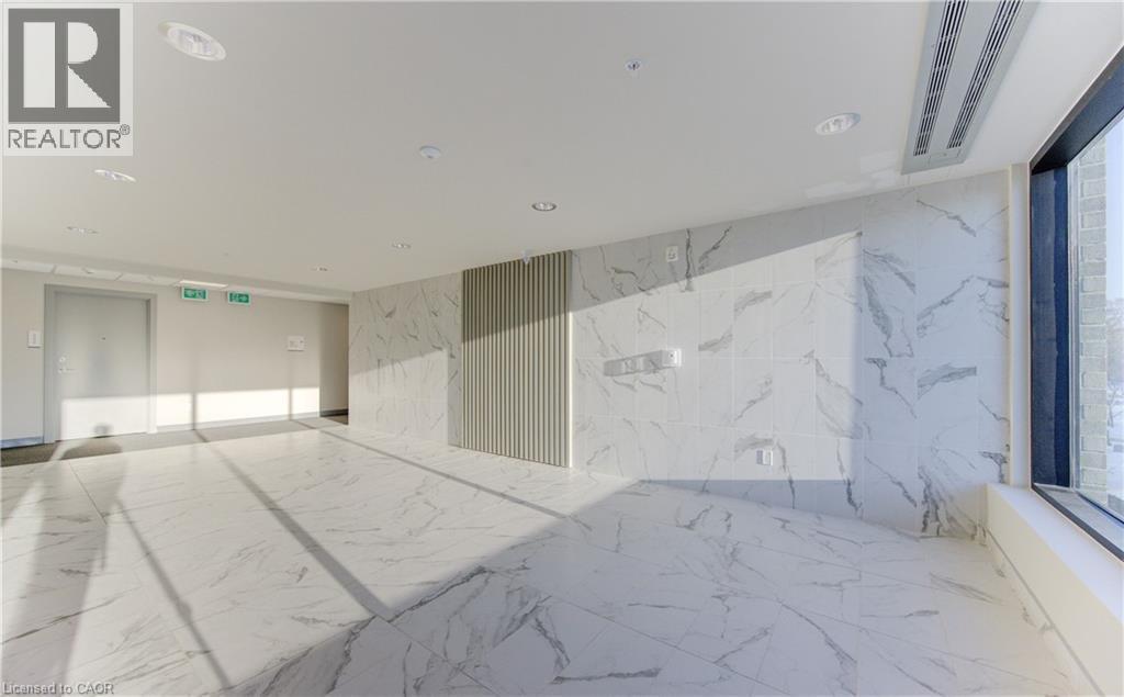 Unfurnished room featuring marble tiled flooring, stone wall, and recessed lighting - 103 Roger Street Unit# 310, Waterloo, ON - Photo Showing Other Room