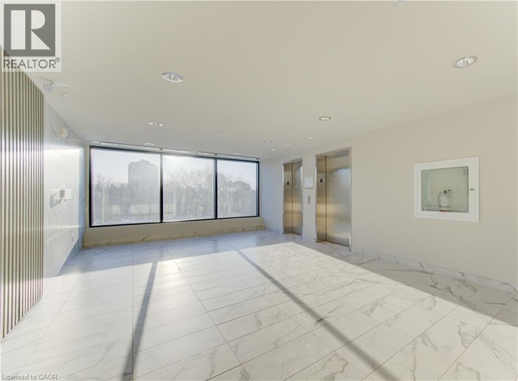 Spare room with elevator and expansive windows - 103 Roger Street Unit# 310, Waterloo, ON - Indoor Photo Showing Other Room