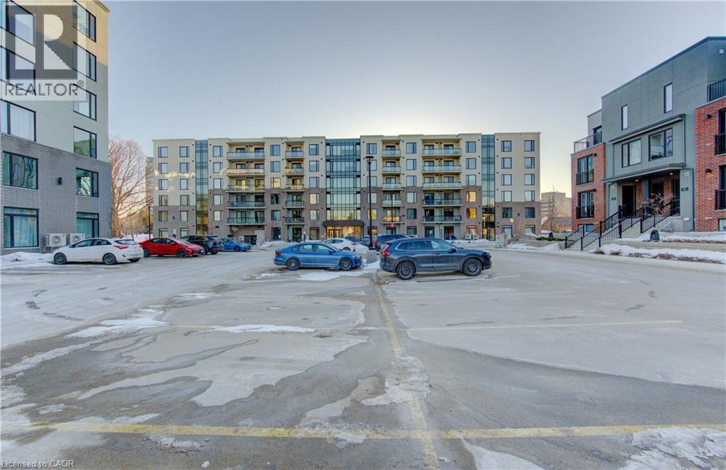 View of uncovered parking lot - 103 Roger Street Unit# 310, Waterloo, ON - Outdoor With Facade
