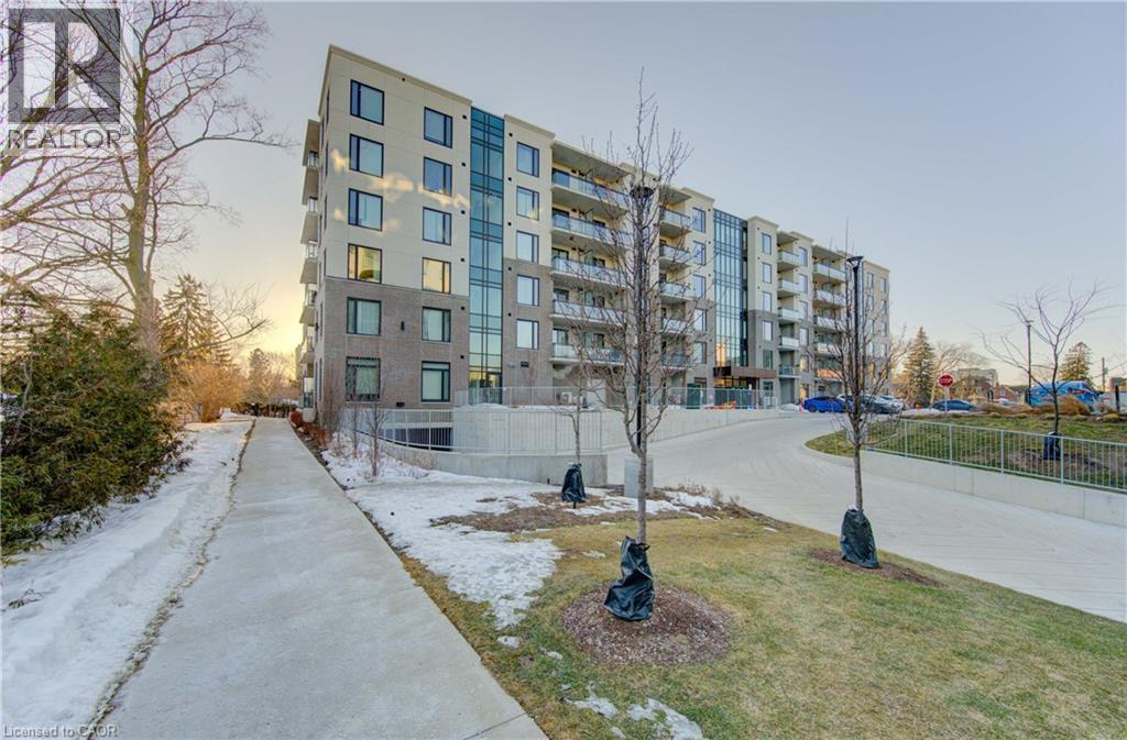 Property at dusk featuring a view of apartment building / complex - 103 Roger Street Unit# 310, Waterloo, ON - Outdoor With Facade