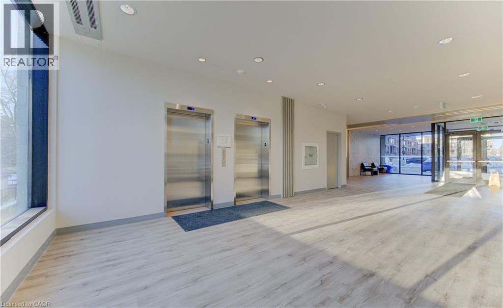 Building lobby with recessed lighting and floor to ceiling windows - 103 Roger Street Unit# 310, Waterloo, ON - Indoor Photo Showing Other Room