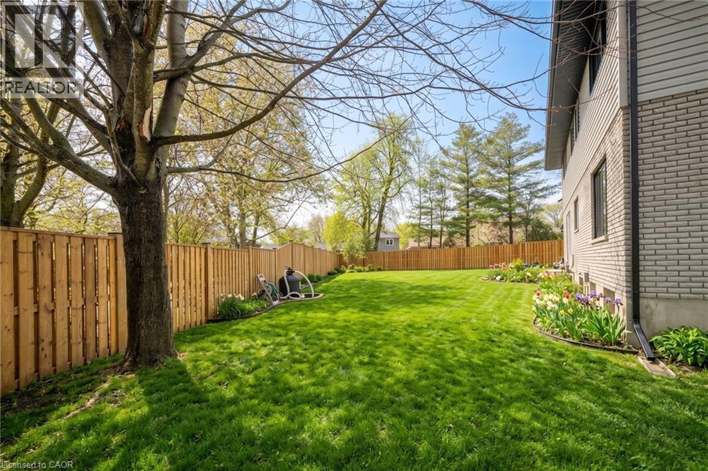 Spacious backyard with a vibrant lawn, bordered by a substantial privacy fence - 361 Coleridge Place, Waterloo, ON - Outdoor