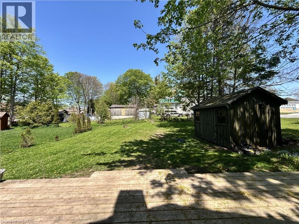 Expansive green lawn with mature trees and a dedicated storage shed - 101 John Street E, Wingham, ON - Outdoor