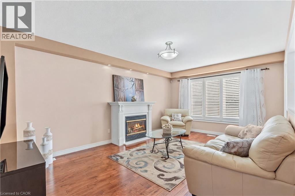 Living area featuring light hardwood flooring and a glass covered fireplace - 42 Archer Way, Hamilton, ON - Indoor Photo Showing Living Room With Fireplace