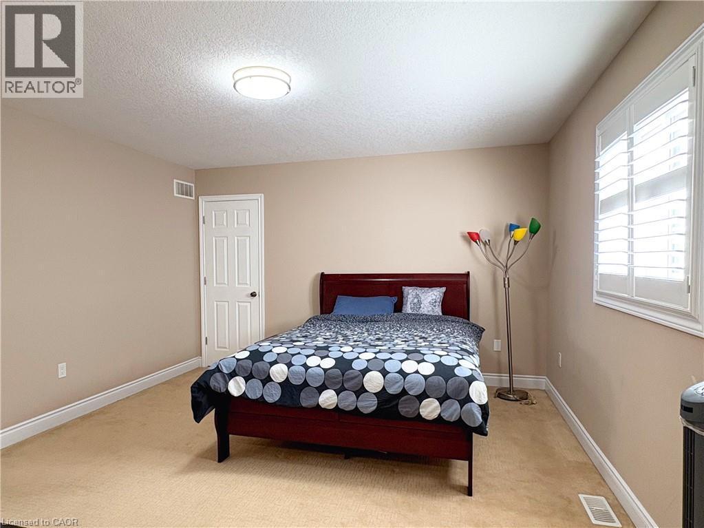 Carpeted bedroom featuring multiple windows and a textured ceiling - 34 Watervale Drive Unit# Upper, Kitchener, ON - Indoor Photo Showing Bedroom