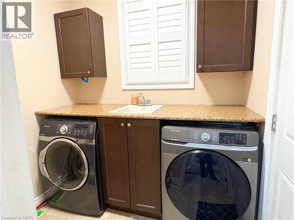 Washroom featuring cabinets, washer / clothes dryer, sink, and light tile patterned floors - 34 Watervale Drive Unit# Upper, Kitchener, ON - Indoor Photo Showing Laundry Room